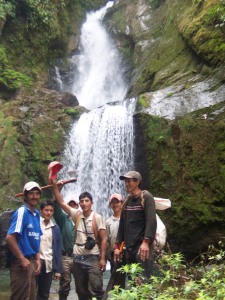 the expedition group in front of a waterfall 